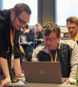 Manfred Steyer gebeugt über Teilnehmer des Angular Camps